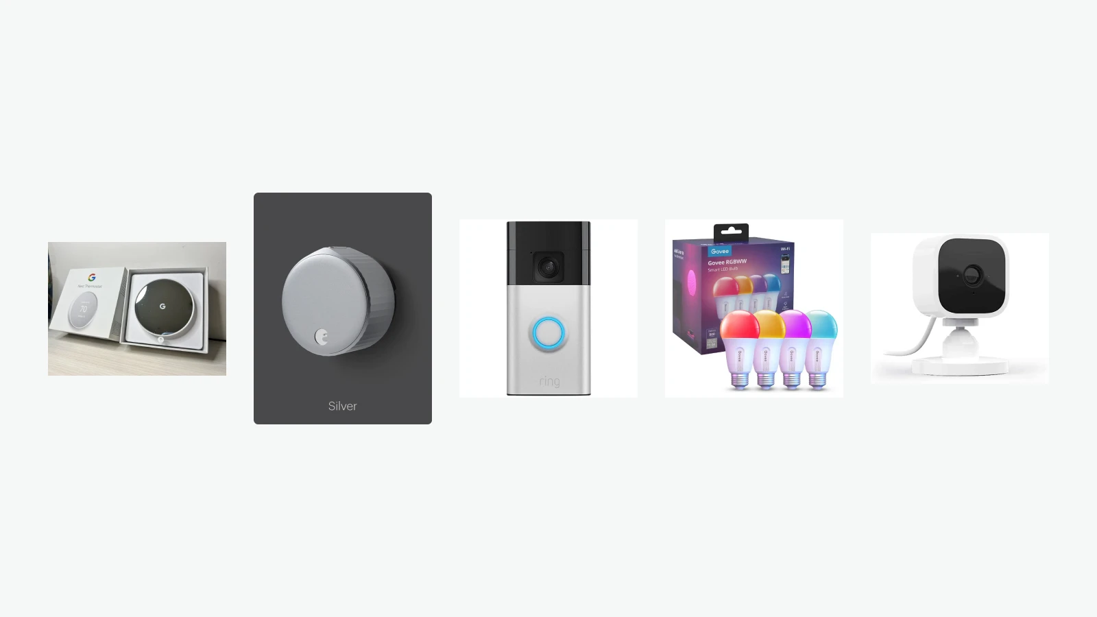 Google Nest Thermostat, August Wi-Fi Smart Lock, Ring Battery Doorbell, Govee smart bulbs and Blink Mini arranged on a light background